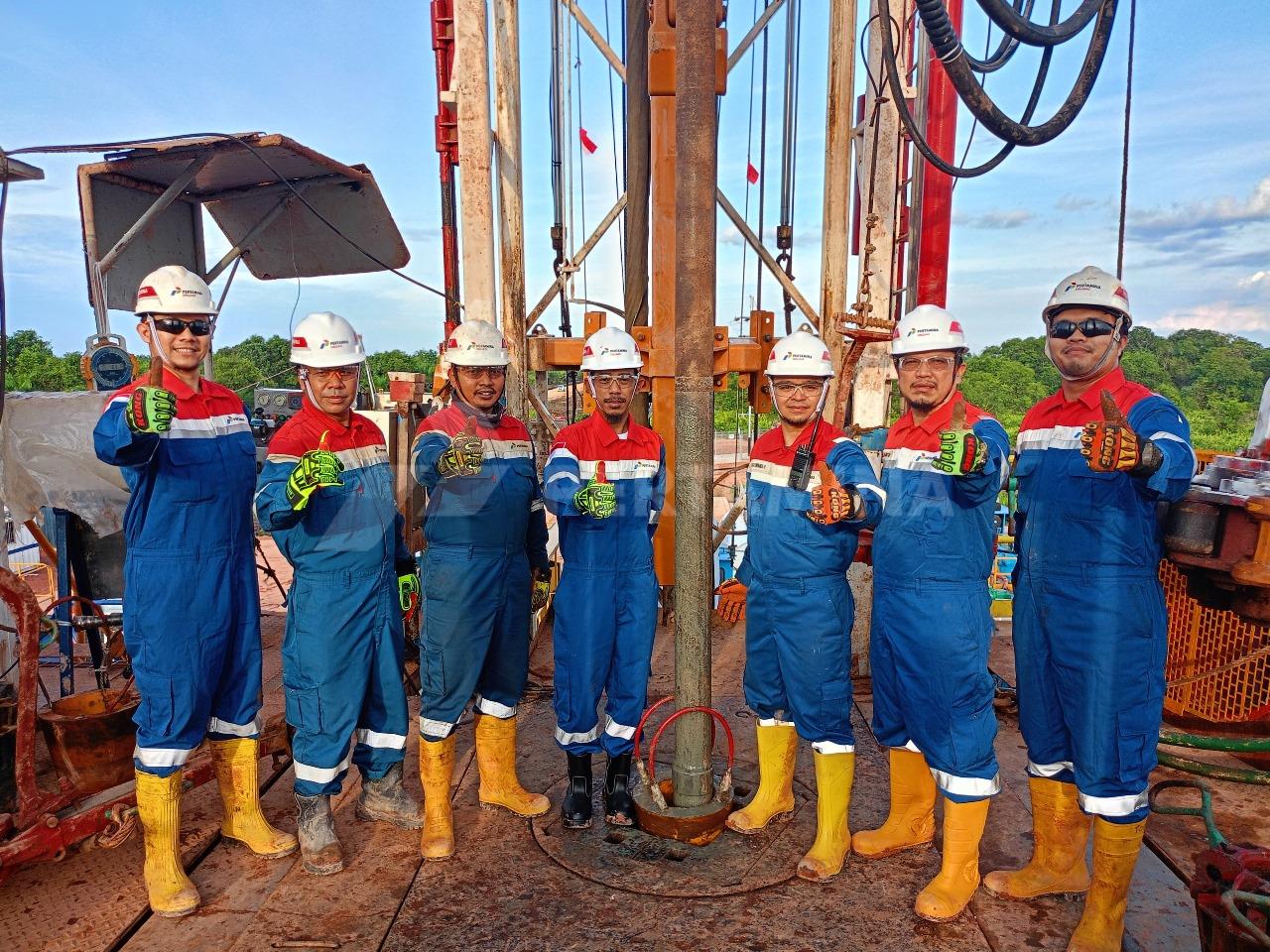 Tim PDSI menunjukkan Salam Lima Jari di lokasi pengeboran